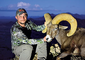 Matt Woodward with a desert bighorn sheep he shot last month.