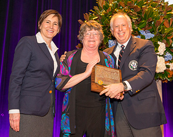 Dr. Patricia J. Vittum, center, is presented with the Green Section award by Kimberly Erusha, USGA Managing Director, Green Section and William L. Katz. (Copyright USGA/Chris Keane)