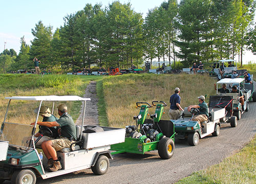 The cart parade heading to the back nine holes pauses to receive directions from Joe Sell, senior assistant superintendent of Whistling Strait's Straits course.