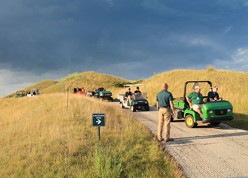 Senior Assistant Superintendent Joe Sell directs traffic with rain clouds overhead ready to pour buckets on the crew.