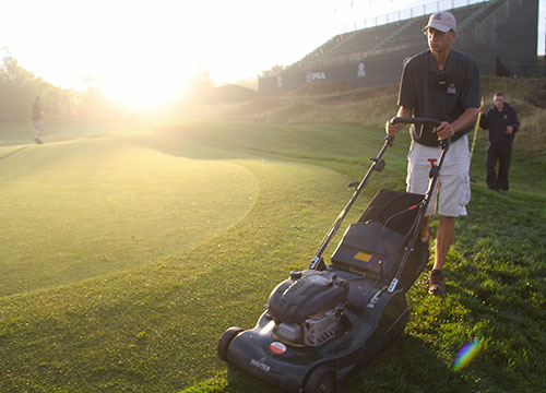 Walk mowing the green surround on No. 6.