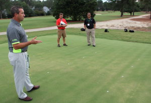 BASF's Gary Myers, foreground, talks about the research plots at Pinehurst while Brad MacDonald, Granite Links GC at Quarry Hills, and Josh Kopera, Harrell's, listen.