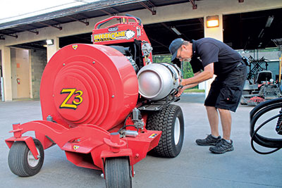 Eric Kulaas, the Vinoy’s equipment tech supervisor, changes a fuel tank on the clubs’ stand-on blower, which has been converted to use propane.