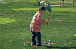 Child teeing off on mini course (Photo: Cattail Creek Mini Course)