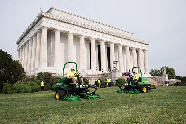 Volunteers mowing near the Lincoln Memorial. (Photo: Kevin Dietsch)