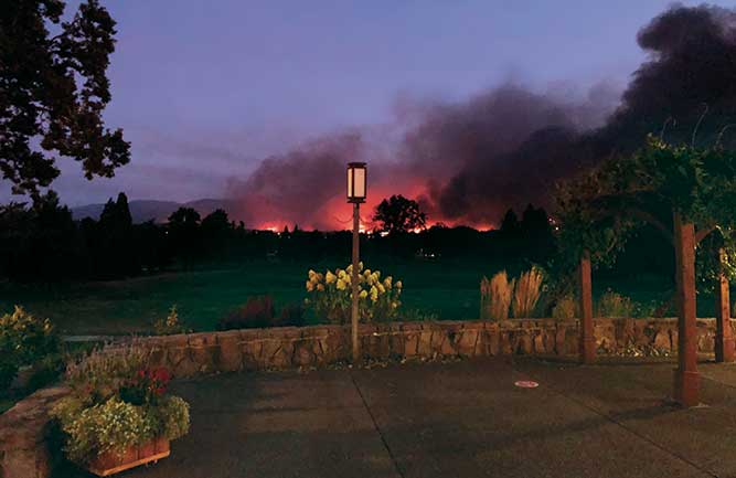 A wildfire blazes in the distance as seen from Rogue Valley Country Club, Medford, Ore. (Photo: Craig Hilty)