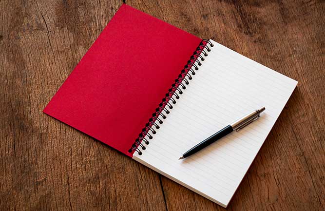Pen and red notebook (Photo: NooMUboN / iStock / Getty Images Plus/ Getty Images)
