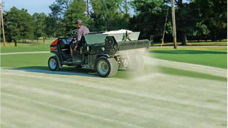 A drop-style topdresser can deliver sand to the putting surface with high precision. This operator is applying 1 cubic foot of sand per 1,000 square feet. (photo by: Brian Whitlark, USGA Green Section)