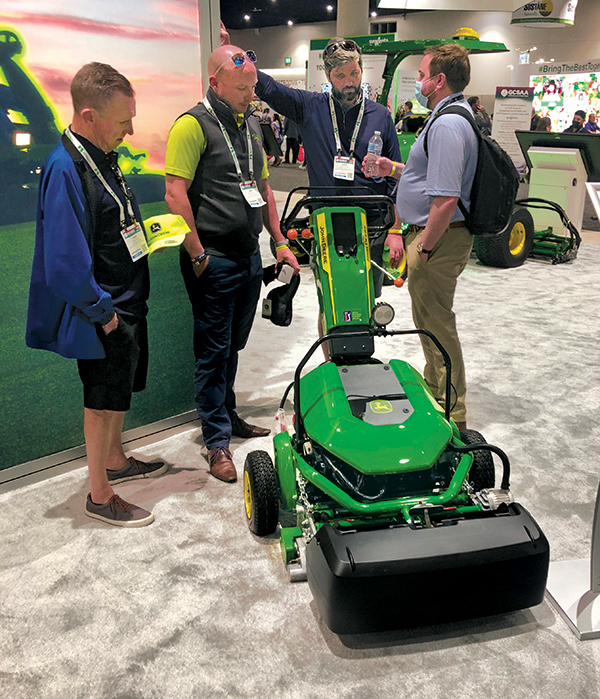 Attendees scope out the 185 E-Cut Electric Walk Greens Mowers at the John Deere booth. (Golfdom Staff)