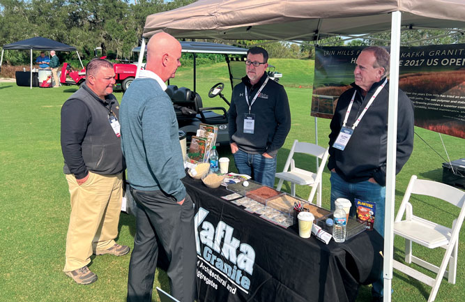 Jim Pavonetti and Glen MacDonald learn more about Kafka Granite’s wax polymer pathway mix from company owner Glenn Kafka (right). (Photo: Golfdom Staff)