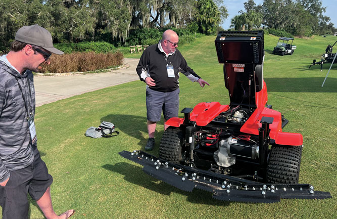 Jeff Churchill of Smithco walks superintendent Derrick Dreyer of Frost Creek through Smithco’s battery-powered bunker rake. (Photo: Golfdom Staff)