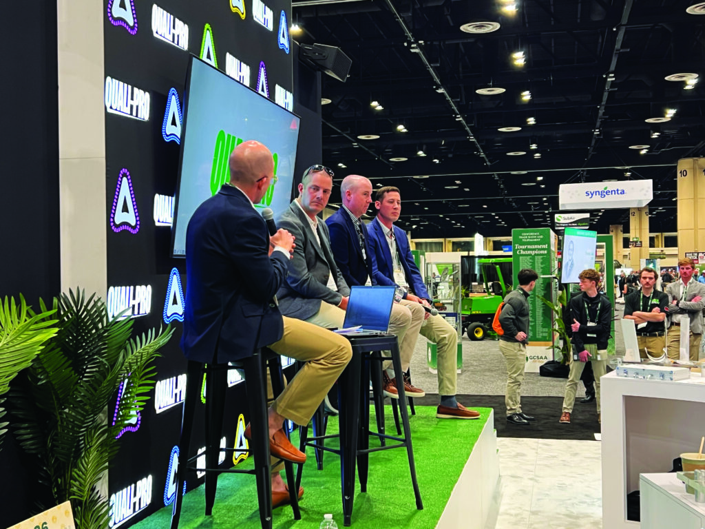 Dave Delsandro (with back to camera) of Agronomic Advisors moderated a lively panel discussion at the Quali-Pro booth. Joining him on stage are Mike McCormick, Oakmont CC; Rich McIntosh, Colonial CC; and Kyle Steidel, Caves Valley GC. (Photo: Golfdom staff)