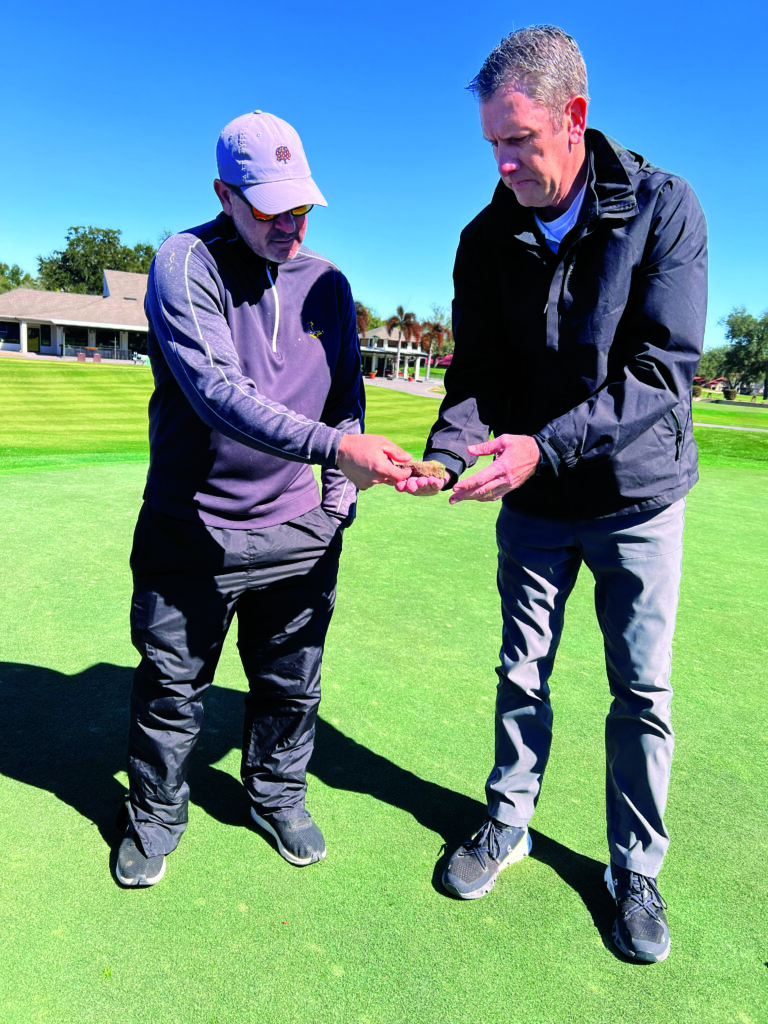 Rob Torri (left), superintendent and assistant general manager at Orange Tree GC in Orlando, looks at some roots taken from a green with Matt Giese, Syngenta’s technical service manager for the Midwest. (Photo: Golfdom staff)