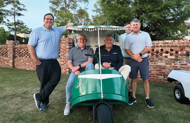 A vintage ride: At the Textron house in Augusta, the Golfdom guys — Scott Hollister, editor, and Jones (seated) — were welcomed by (left to right) Dave Tennant, E-Z-Go; Brandon Haddock, Textron (somewhat hidden behind the vehicle… who took this photo?!?); and Kevin Blanton, Textron. (Photo: Golfdom staff)