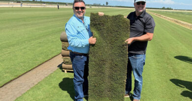 Roberto Gurgel and Joel Lane with a slab of HighPoint Bermudagrass. (Photo: Sod Solutions)
